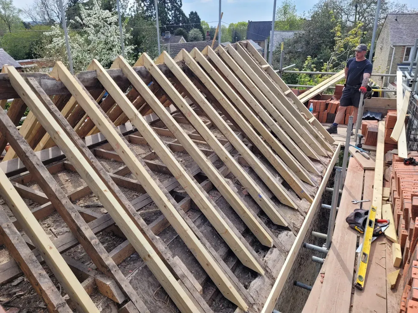 Roofer working on new pitched roof timber structure during installation or replacement by Ox Roofing Ltd